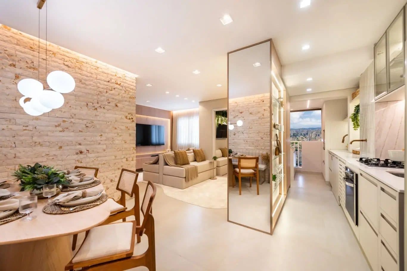 Sala de jantar integrada com parede de tijolinhos e cozinha ao fundo
