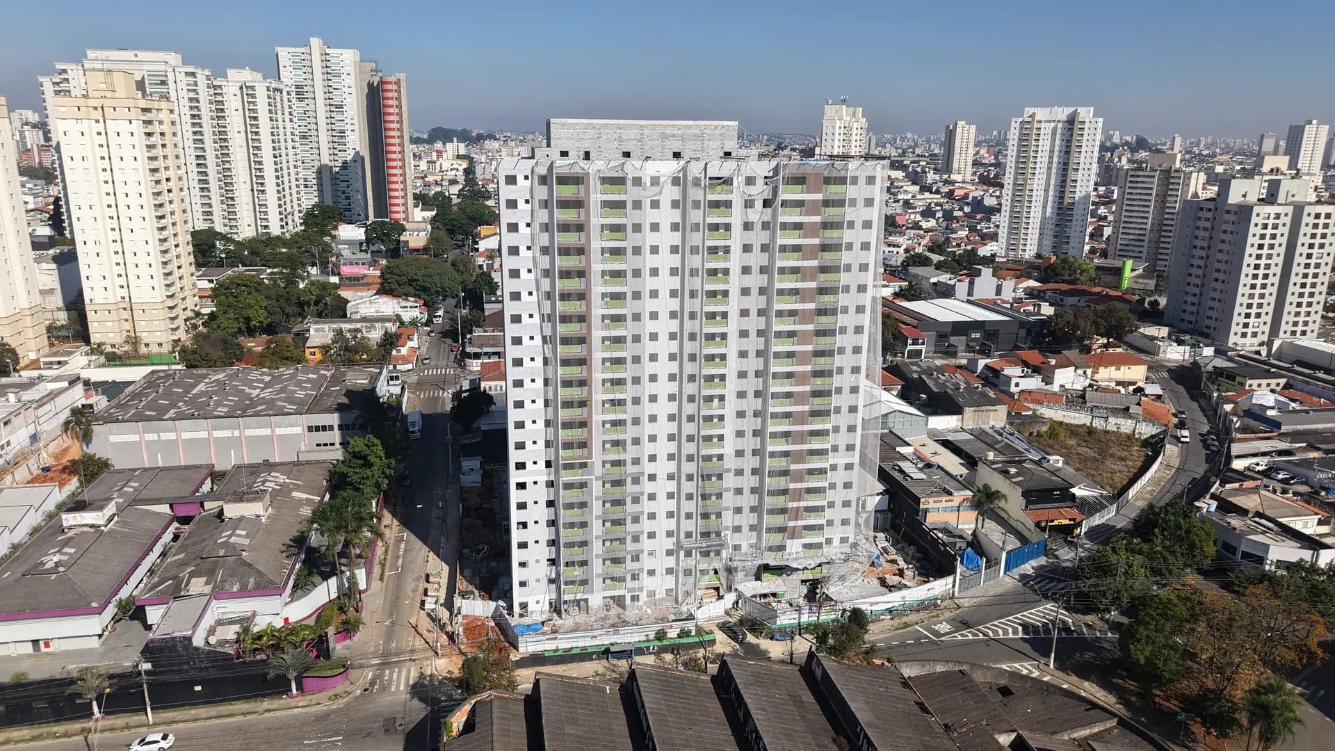 Vista aérea da torre principal em fase de construção com a cidade ao fundo