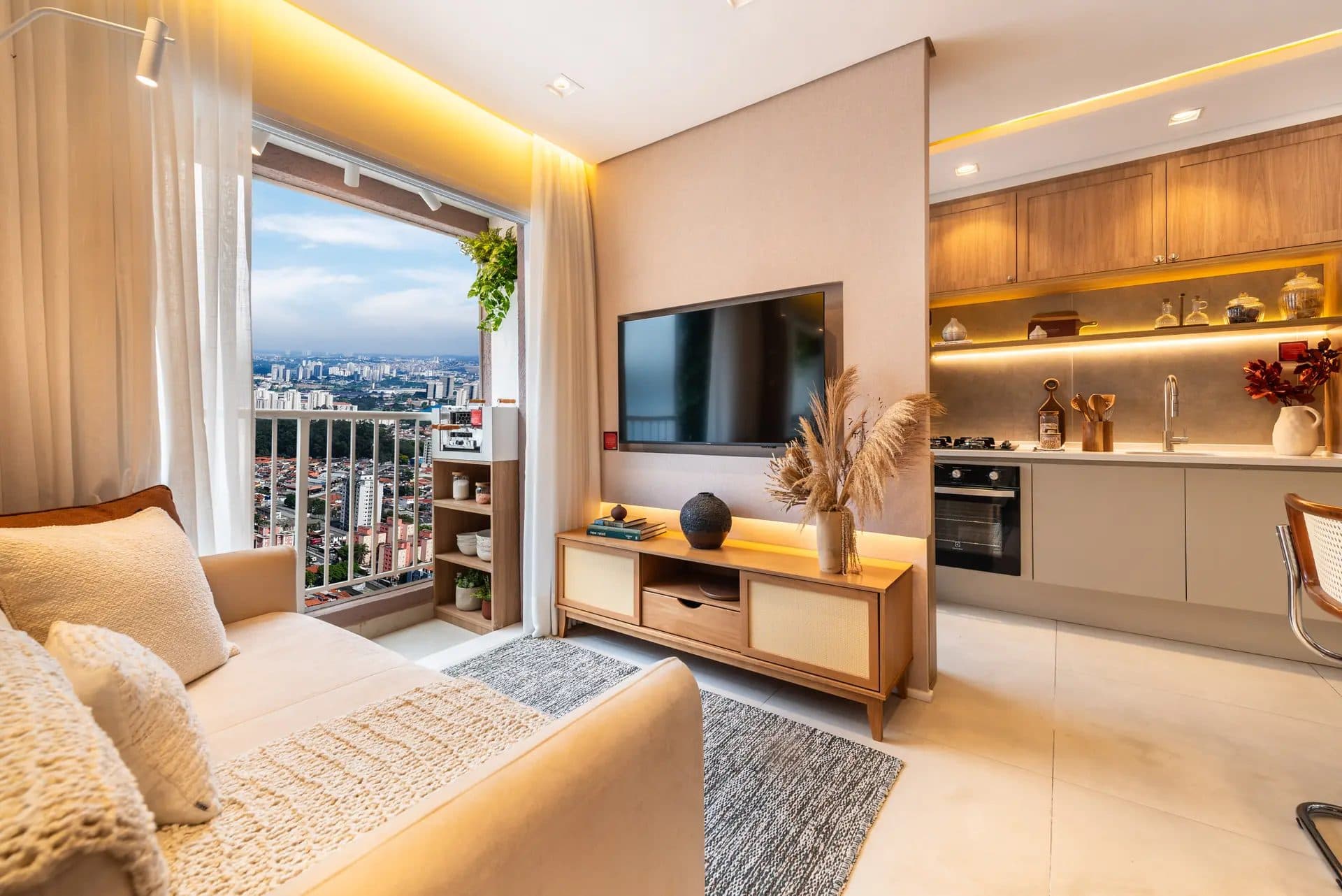 Sala de estar integrada com rack para TV e acesso à varanda com vista panorâmica.