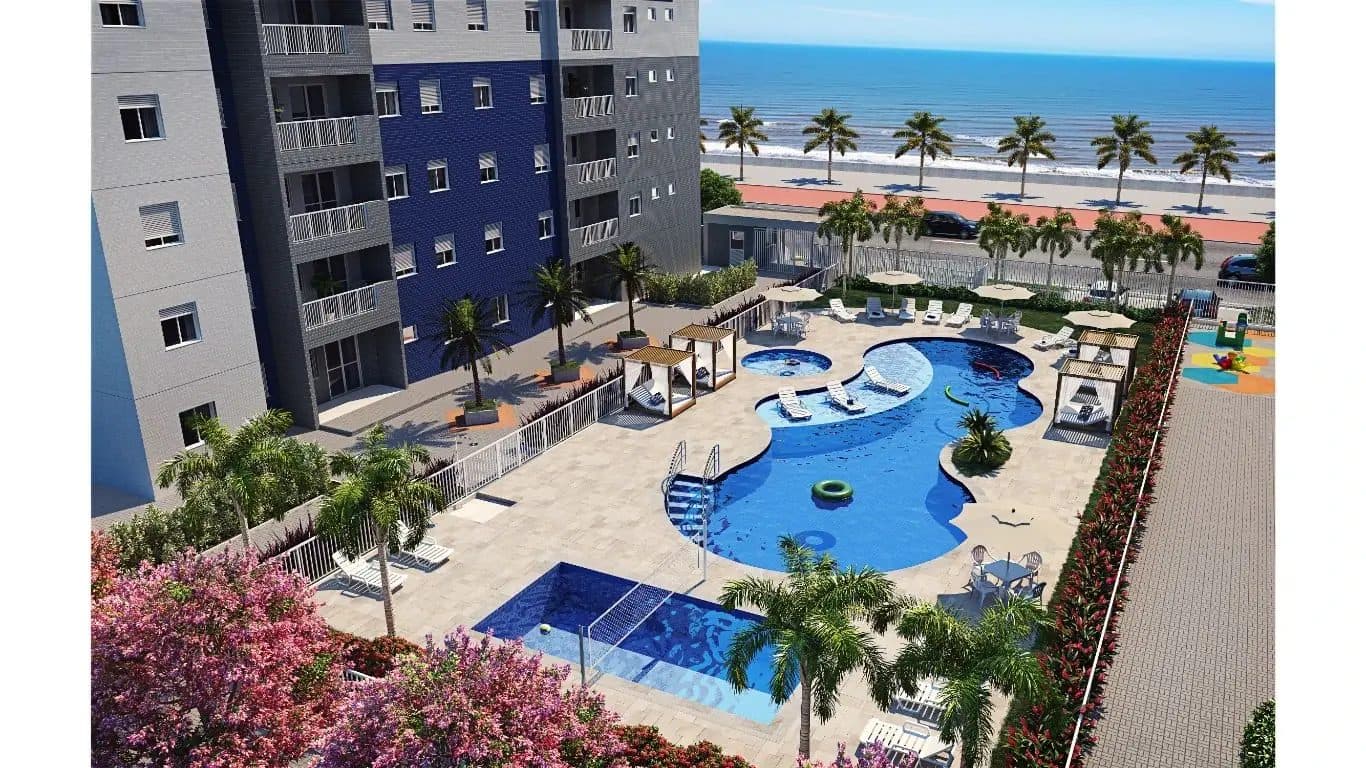 Área de lazer externa com piscina ampla, espreguiçadeiras, guarda-sóis e vista para o mar.